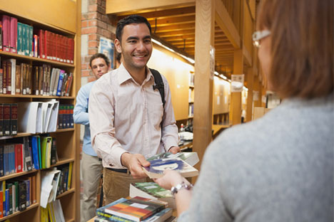 man at the library holding books